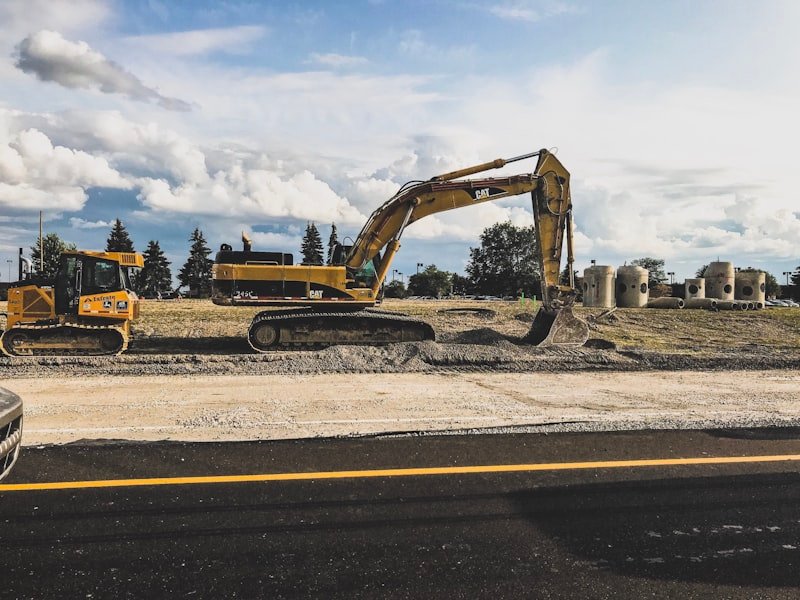 Excavator breaking out and removing an old asphalt driveway for full replacement