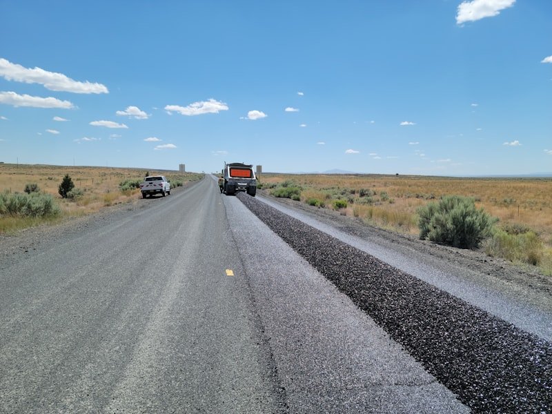 Paving train resurfacing a road with a new hot-mix asphalt overlay