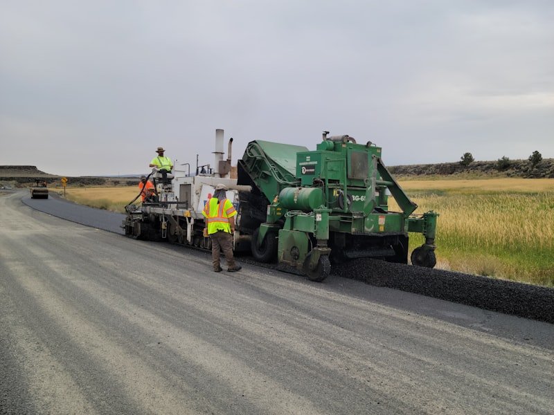 Paving crew patching and repairing a damaged asphalt surface