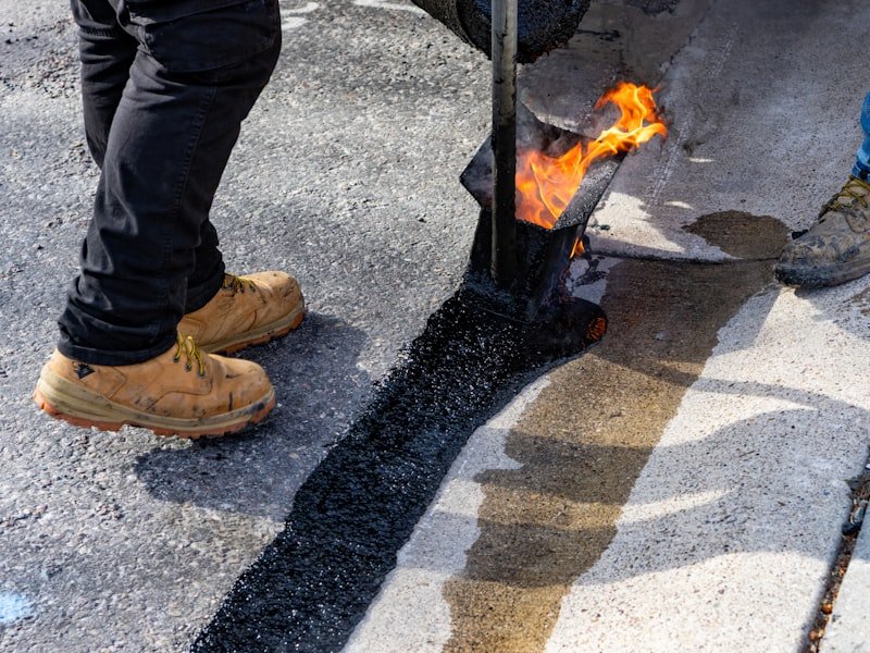 Hot-applied crack sealing with a torch on dark asphalt